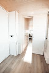 The bedroom barndoor and the bathroom pivot door are sided in the same pine T&G as the walls and ceiling. 