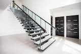 Custom metal fabrication with glass railing on these stairs echo the clean, modern look that emanates throughout the home. 
