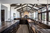 Dark cabinets and wood beams create a stunning contrast to the white, clean walls in this kitchen and dining area.