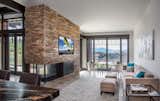 A beautiful stone wall houses the television as well as the fireplace for a cozy feel in a sitting area just off of the kitchen.