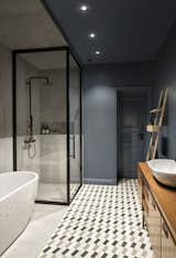 The warm-colored vintage teak sideboards and towel racks contrast the cool, dark bathroom walls beautifully.&nbsp;&nbsp;