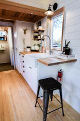 The kitchen provides a surprising amount of storage space for a tiny home. There is also a full-size sink, stove, and refrigerator. 