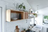 Tiny kitchen in a Tru Form Tiny, Urban Park Studio. Features a hickory kitchen shelf, organic white tile, butcher block counters, apron front sink, and farmhouse accents.  