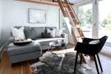 Storage sleeper sofa and ladder access to loft in an Urban Park Studio by Tru Form Tiny
