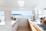 A young Vancouver family asked Falken Reynolds Interiors to convert their waterfront vacation home on British Columbia’s Sunshine Coast into their primary residence. To facilitate livability for the foursome, an enlarged kitchen, complete with a large white island with wood hardware, was a major part of the renovation.