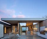 A front courtyard is an extension of the kitchen. Both kitchen millwork and concrete bench in the entry extend through the glazing. 