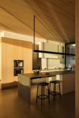 A custom steel pendant illuminates the island as well as shines light up onto the Hemlock ceiling. 