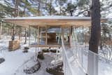Looking the living block from life related watery block.
Sloped steel posts are connected to two separate levels, wooden lattice-work stilt floor and square roof. The Japanese cedar used for eaves soffit material are listings from log sawing process, and these are assembled and constructed.