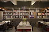 The grid mild steel hung on the wall parallel to the work station table  maximize storage and becomes effective with proximity. 
The wooden hand made hanging lights lit directly on the table which becomes comfortable while working.
