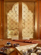 Salon with Sliding Doors – A pair of bespoke Moroccan-style sliding doors with eglomise glass panels and teak frames.. Eglomise is a process that introduces a gilded pattern on the surface of a piece of glass which is then protected by a second piece of glass fitted on top: each door is gilded and varnished. 
