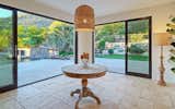 Dining Area With Walls Of Glass Open To Pool And Backyard