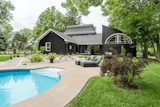 A large outdoor space to view the back of the home with multiple roof lines and the large semi circular window to the loft which is a unique architectural element adding great natural light to this space.