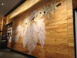 Reclaimed American Gothic Hickory as wall cladding is enhanced with a custom mural in a retail store. 