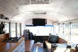 Living Room, Wood Burning Fireplace, Ceiling Lighting, Sofa, and Vinyl Floor This is our living space, our couches were built to fit our entire family comfortably. We have storage underneath each of the couches and in the armrests.  Photo 8 of 9 in Blue Steel, Our Self Coverted School Bus Tiny Home by Ashley