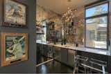 The antiqued mirror walls in the wet bar add depth to the space. 
