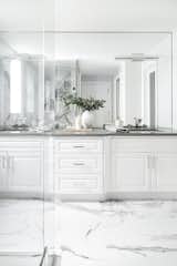 The ensuite needed to feel crisp and clean. We used the existing cabinetry and refinished it in a white, replaced the dated granite countertops, and created a marble oasis. 
