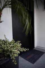The entrance features a custom steel black door, integrated with a smart home system that can be unlocked with a smartphone.