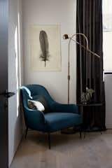Blue velvet armchair with black stained oak side table in the guest room. Feather print on handmade Nepalese paper by an artist in Brooklyn, New York.
