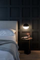 Contrasting black and white orb pendants on both sides of the bed provide warm light for bedtime reading or for writing in the guest journal.