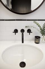  Black powder-coated faucets contrast the white sink and tiles.