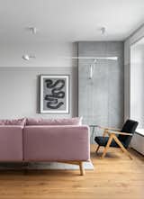 The living room is an area for communication – at the request of the clients, neither television nor projector was provided. Powdery sofa contrasts profitably against the electric blue curtains. Plus, the graphic work of the artist Yulia Popova comes up visually as the centre of the living room. As an essential lighting element, the iconic Flos 265 was used here.