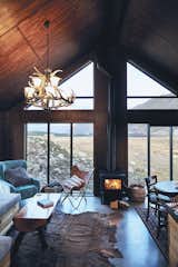 Living Room, Coffee Tables, Wood Burning Fireplace, Pendant Lighting, Chair, Concrete Floor, and Sofa  Photo 9 of 10 in High Country Cabin by Kenny Smith