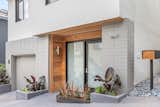 Recessed entry with cedar siding and large glass door replaced one garage space. 