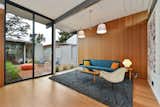 Living room with bamboo flooring and bamboo wall panels in place of damaged mahogany wall panels