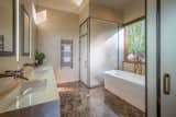 The master bath has large floor slabs of Emperador marble, onyx counters, and acid-etched glass enclosures for toilet and shower.