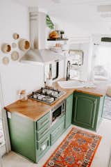Kitchen, Light Hardwood, Range Hood, Microwave, Cooktops, Ceramic Tile, Drop In, Colorful, Wood, Ceiling, and Rug "Nobody thought it could be done," states Lauren. "I painted the design plans and posted them on our social media. I'm positive people thought we were foolish wanting to make this old RV look like a tiny home, but voila—isn't she a beauty?"

  Kitchen Wood Range Hood Colorful Drop In Ceramic Tile Light Hardwood Photos from The Cougar