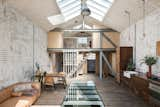 Skylights running down the middle of the pitched roof bring light into the space and into the floor below.

Sections of reinforced glass have been fitted into the concrete floor, filling the ground floor with light.