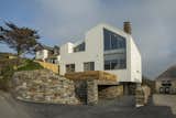 Exterior, Stucco Siding Material, House Building Type, and Saltbox RoofLine The lower-ground floor and the walls supporting the raised front garden are clad in stone, making it look like it is perched on a rock.  Photo 10 of 11 in A UK Home With Panoramic Ocean Vistas Asks $3.5M