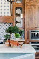 Kitchen, Marble Counter, Microwave, Wood Cabinet, Colorful Cabinet, Drop In Sink, Ceramic Tile Backsplashe, and Wall Oven  Photo 8 of 9 in Mado Manor Homes by Serenbe 