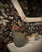 Stone mirror detail, traditional polished nickel faucets and a vintage Japanese bud vase