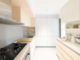 The neat kitchen is meticulously refined in proportions and the use of colors