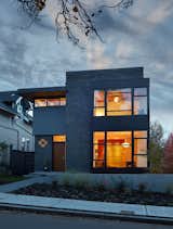 Exterior - The dark exterior color scheme was selected to allow the house to visually recede in its prominent corner location, while interior colors and window placements flood the space with daylight.
