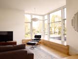 The box is further broken by bay windows at the living room and master bedroom, maximizing space that would otherwise be limited by zoning setbacks. In the living room the flooring continues into the bay window seating.