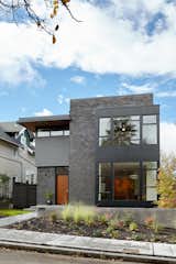Front Elevation - The dark exterior color scheme was selected to allow the house to visually recede in its prominent corner location, while interior colors and window placements flood the space with daylight.