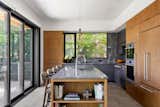 This new home nestles amongst the trees of a watershed to take advantage of smaller moments of privacy in an otherwise urban environment. Mid-century lines divide airy interior volumes anchored by a concrete garage. Using screens and sliding doors to create spaces that can transform based upon need.