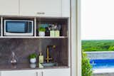 And a separate kitchen with grey marble countertop and backsplash.