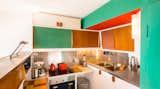 Kitchen, Medium Hardwood Floor, Cooktops, Metal Counter, Laminate Counter, Wood Cabinet, Accent Lighting, Drop In Sink, Colorful Cabinet, White Cabinet, Wall Lighting, and Metal Backsplashe Rebuilt Kitchen in 2017  Photo 4 of 17 in Corbusier Re-Renovation Berlin by Philipp Mohr