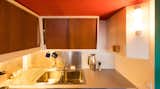 Kitchen, Medium Hardwood Floor, Cooktops, Refrigerator, Colorful Cabinet, Metal Backsplashe, White Cabinet, Accent Lighting, Wood Cabinet, Wall Lighting, Laminate Counter, and Drop In Sink Rebuilt Kitchen 2017  Photo 6 of 17 in Corbusier Re-Renovation Berlin by Philipp Mohr