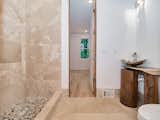 Full bath on main level connects to secondary bedroom and foyer; features custom wood counter space and tile work