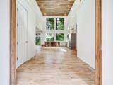 View from double front door on street side of home - 20 foot ceilings and floor to ceiling windows make for a dramatic entrance. All wood on ceiling and trim repurposed from original 1920s cabin
