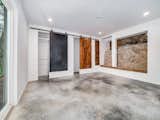 Terrace level secondary bedroom features sliding barn doors, view of original stone wall, floor to ceiling windows with view to lake