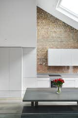 Kitchen, Light Hardwood, Dishwasher, Engineered Quartz, Refrigerator, Undermount, Track, Accent, Cooktops, Ceiling, Recessed, Range Hood, and White Front Detail of the Kitchen  Kitchen Cooktops Recessed Accent Engineered Quartz White Refrigerator Undermount Photos from Olympia Loft
