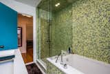 Separate rain shower and mossy green penny tile transport you away from busy metro Detroit.