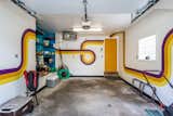 Retro painted 1 car garage features a heater for winter months with easy access to the basement refrigerator, laundry and utility room.