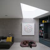A wedge-shaped skylight allows natural light to suffuse the interiors. The architects preserved a palette of dark, natural materials on the ground floor.