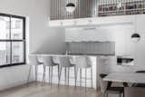 Kitchen, Subway Tile, Wall Oven, White, Refrigerator, Cooktops, Light Hardwood, and Marble  A wood dining table with matte-metal supports is adorned with chairs from InMod.  Kitchen White Refrigerator Light Hardwood Marble Photos from Industrial TriBeCa Loft